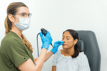 Médica inspeccionando salud auditiva