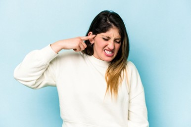 Mujer sufriendo de pito en los oídos